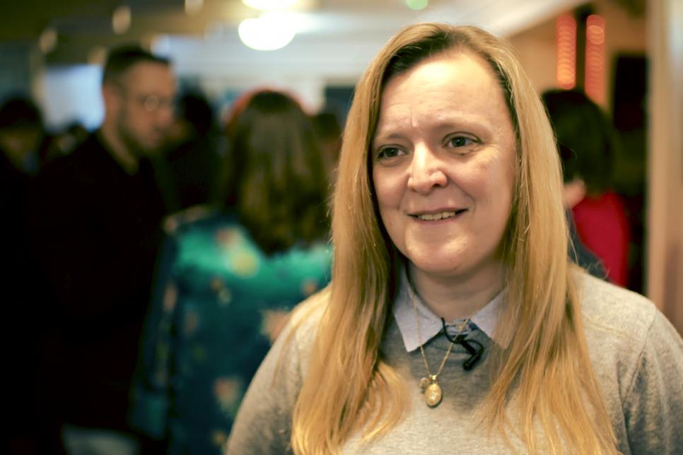 A white woman with blonde hair talks to the camera