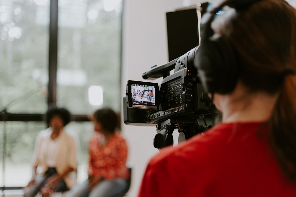 Person filming two people speaking