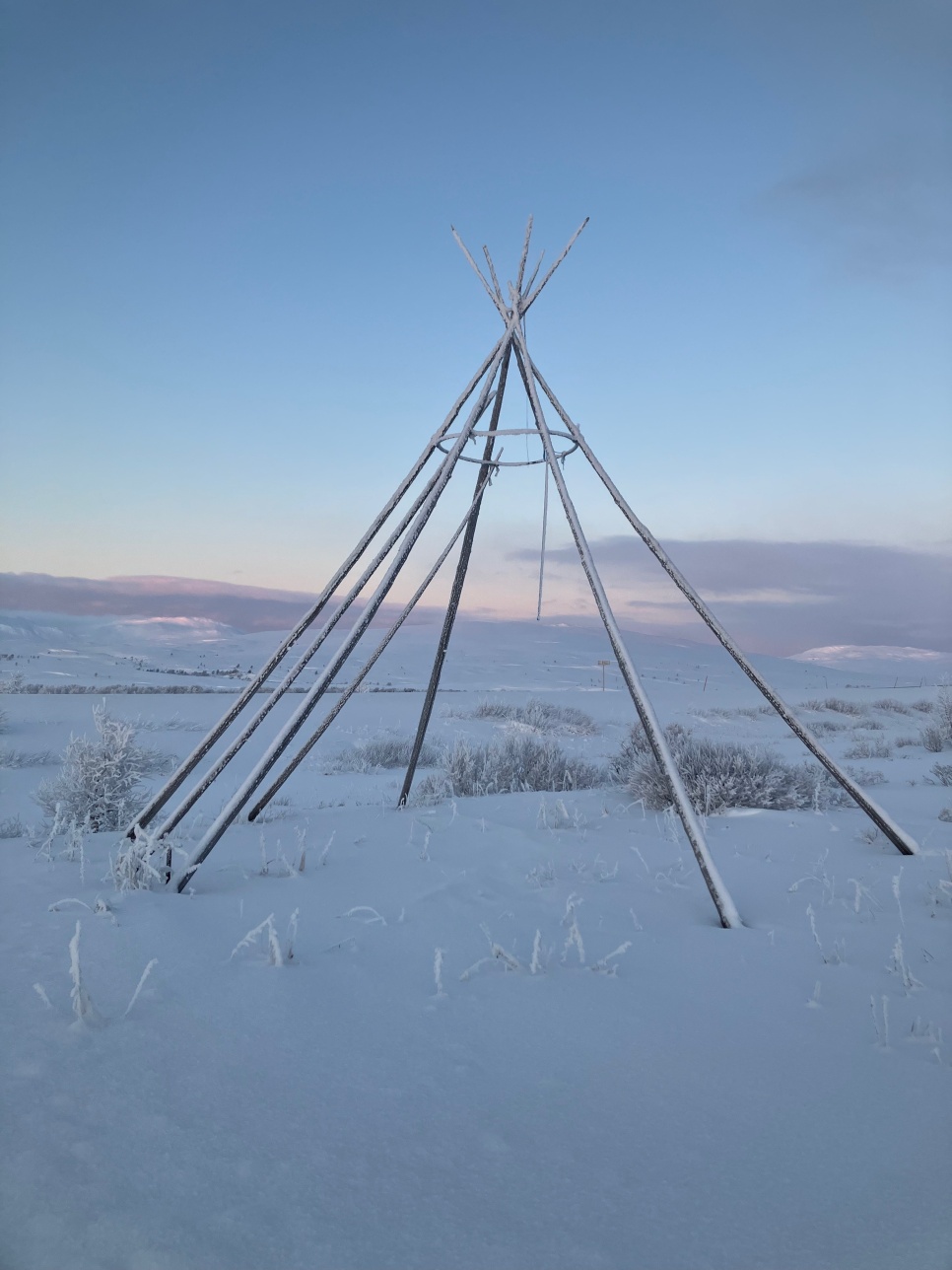 A tent structure of sticks and twine in the snow